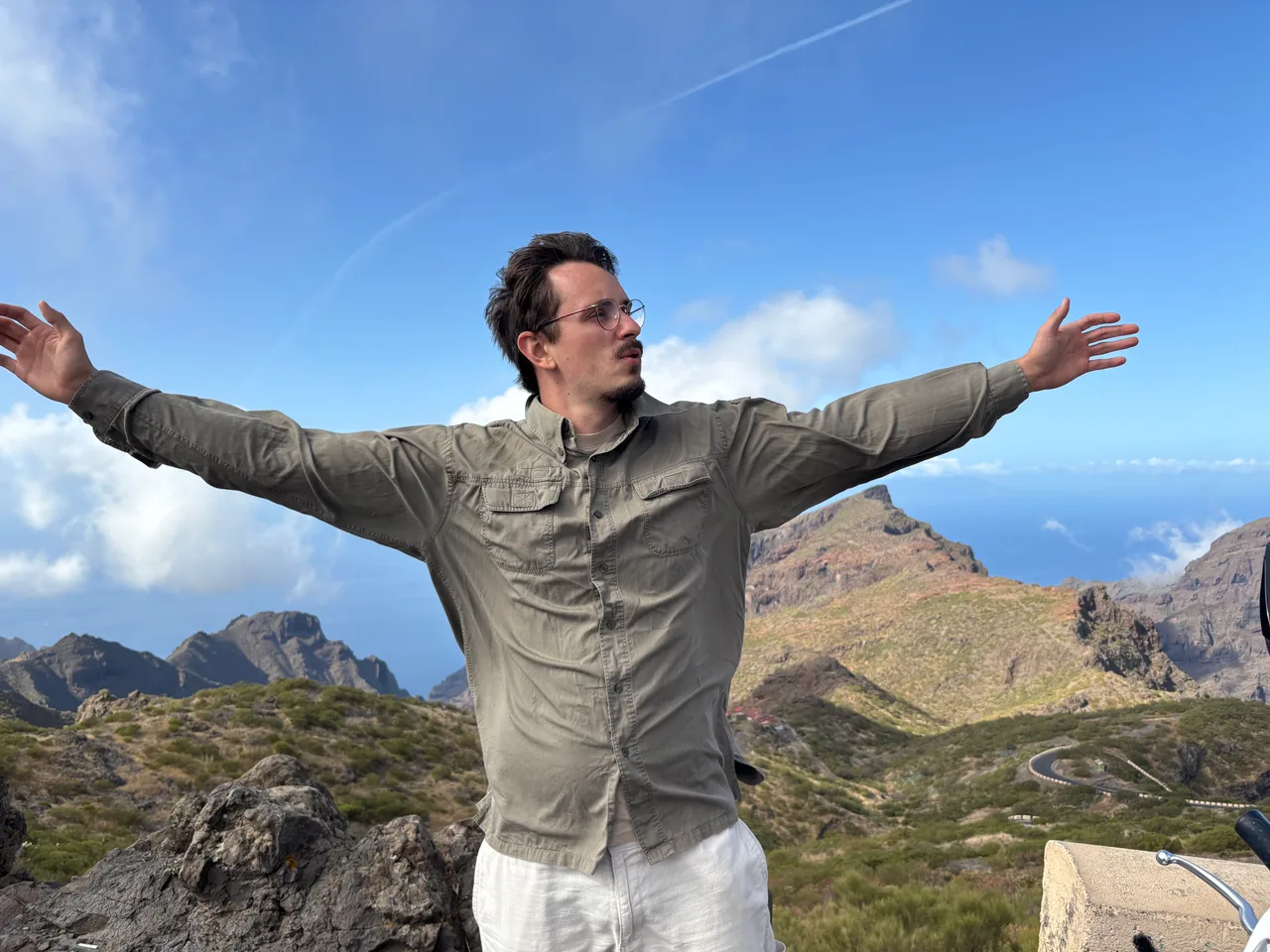 Kevin Otto Lais mit ausgebreiteten Armen vor einer felsigen Berglandschaft